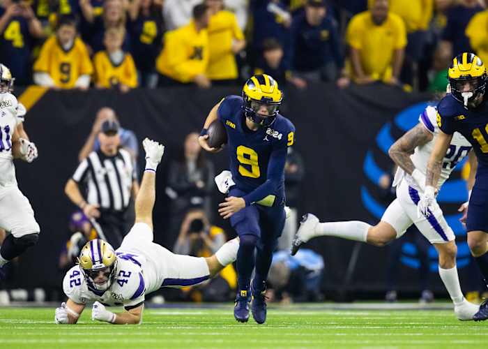 Jan 8, 2024; Houston, TX, USA; Michigan Wolverines quarterback J.J. McCarthy (9) runs with the ball against Washington Huskies linebacker Carson Bruener (42) during the third quarter in the 2024 College Football Playoff national championship game at NRG Stadium.